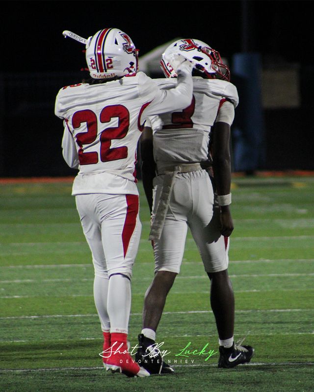 Two team mates walking off arm in arm after a play