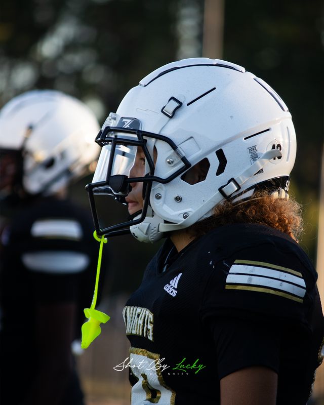Profile of a player in a white helmet on the sideline
