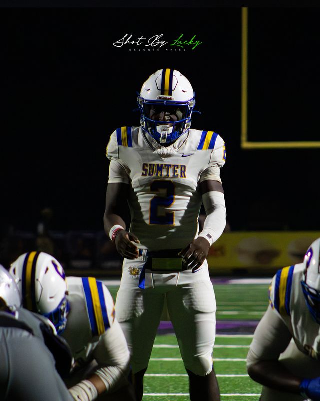 A player standing in the dark between plays