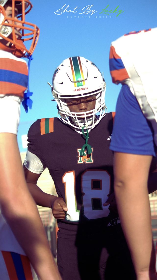 A player on the sideline against a clear sky